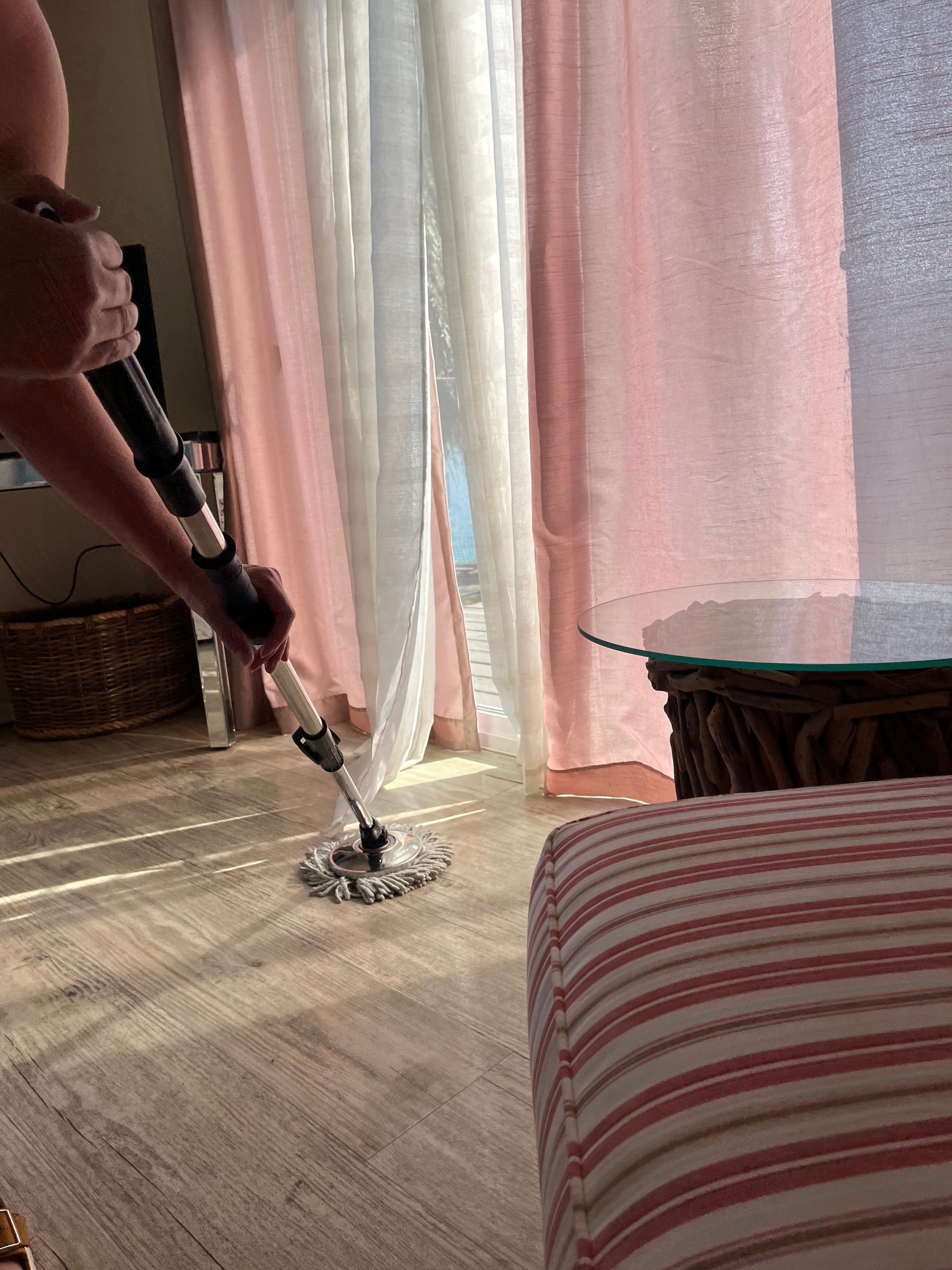 Professional cleaner mopping a bedroom hardwood floor.